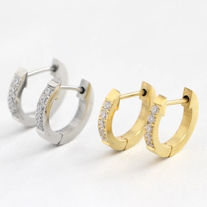 Macro shot of gold and silver stainless steel 9mm hoop earrings with cubic zirconia on silk