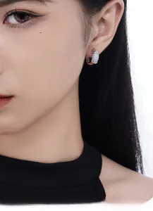 Macro close-up of a silver S925 sterling silver hoop earring with pavé zircon stones on model