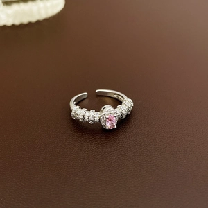 Macro detail of silver ring with pink oval gemstone and sparkling zircon accents