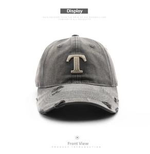Close-up of vintage washed gray baseball cap with distressed holes and T embroidery