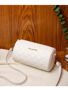 White quilted PU leather cylinder bag detail with gold zipper and adjustable shoulder strap