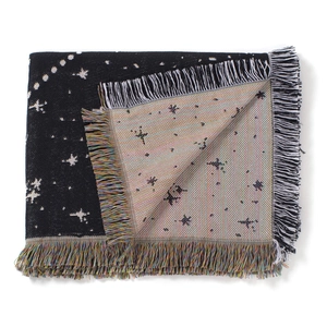Detail view of woven black and white star pattern blanket with colorful tassels