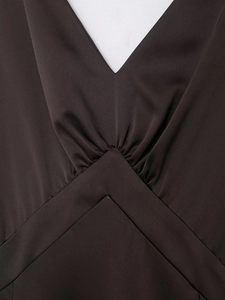 Detailed view of the elegant V-neckline and waist pleats on this satin dress