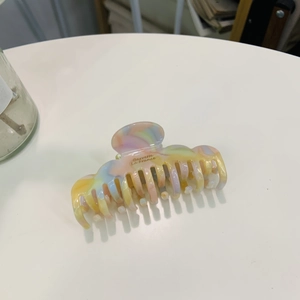 Cloud-shaped iridescent acetate hair claw with colorful marble pattern and gold text