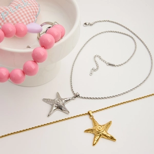 Detailed view of gold and silver starfish pendants on twisted stainless steel chains