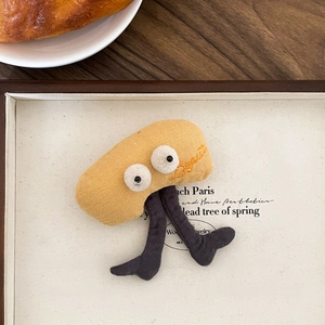 Macro shot of creative yellow plush brooch with Beaut embroidery on wooden table