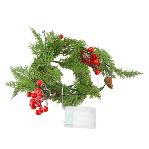 Artificial Christmas garland with pine needles, red berries, cones and battery lights