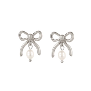 Gros plan sur les boucles d'oreilles nœud argenté et perles blanches sur fond blanc