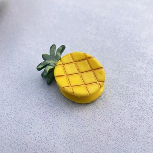 Close-up of yellow checkered pineapple hair claw clip made of acetate resin