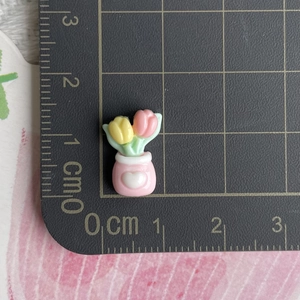 Miniature resin tulip flower pot accessory shown with a metal ruler for size scale