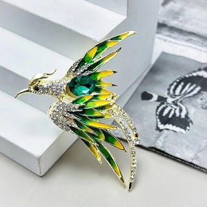 Exquisite phoenix brooch in gold with green gradient enamel and sparkling crystals