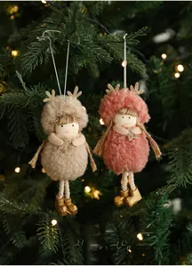 Detail of plush Christmas angel dolls with sequins antlers on a festive lit Xmas tree