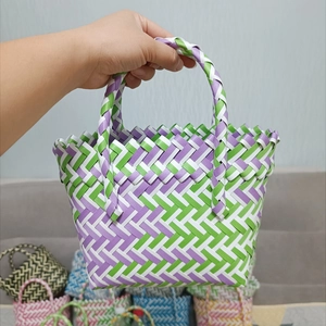 Detailed view of handmade purple and green woven mini basket with double handles
