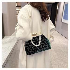 Model view of a dark green leopard velvet shell bag with pearl handle and gold chain strap