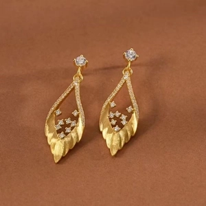 Vue détaillée des boucles d'oreilles feuille d'or avec zircon blanc et finition métal brossé