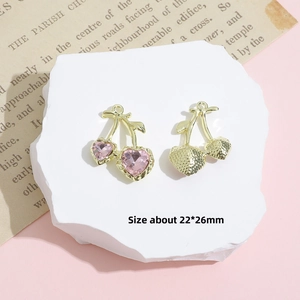 Detailed view of cherry pendants with pink heart crystals and hammered gold finish