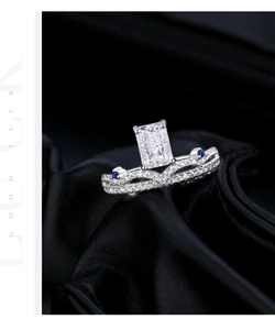 Macro detail of emerald cut crown ring with blue side stones and pavé set diamonds