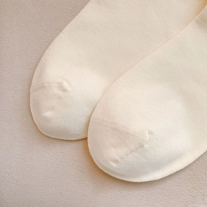 Close-up of seamless toe stitching and breathable cotton texture on cream socks