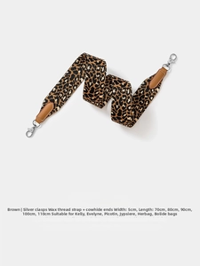 Detailed view of leopard print woven bag strap with brown leather ends and silver metal clasp