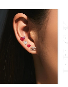 Macro view of 925 silver heart and envelope stud earrings set on a model ear