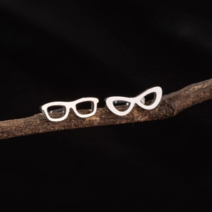 Polished stainless steel stud earrings in mismatched eyewear frame shapes on branch