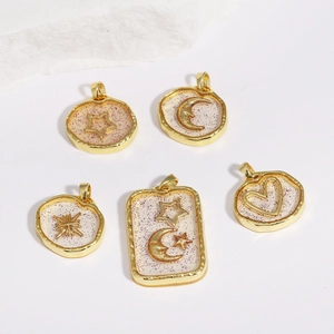 Detail of five gold celestial pendants with star, moon and sun resin glitter charms