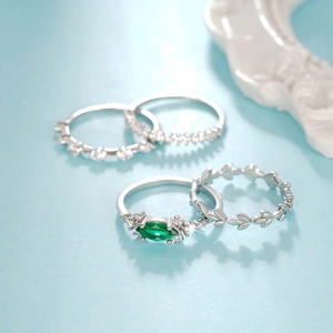 Vista detallada de un set de 4 anillos con piedra marquise verde y motivo de hojas