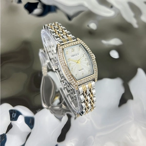Detailed close-up of emerald style dial with rhinestone bezel on gold silver watch