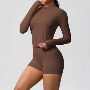 Detail of dark brown zip-up yoga jacket with thumb holes and matching athletic shorts