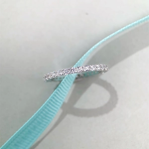 Macro shot of silver S925 ring with sparkling stones and elegant blue ribbon
