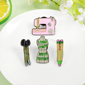 Set of four creative enamel pins featuring pink sewing machine and tailor supplies
