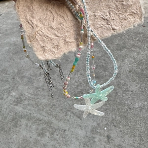 Detailed view of colorful beaded necklace with starfish pendants and silver tube accents