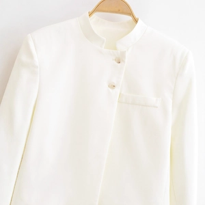 Veste courte blanche minimaliste avec col montant et deux boutons sur un cintre