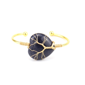 Detail of tree of life wire wrapping on heart-shaped blue sandstone gold bangle