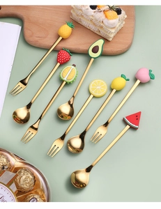 Detailed set of eight golden stainless steel spoons and forks with cute fruit top handles