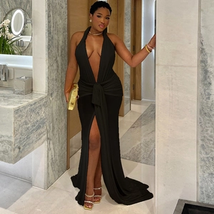Detail of elegant black halter dress featuring deep V-neck, waist ties, and high side slit