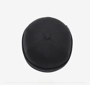 Top down view of black twill cotton brimless docker cap with mountain embroidery details