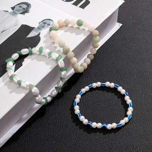 Three-piece bohemian beaded bracelet set featuring pearls, jade beads and evil eye charms
