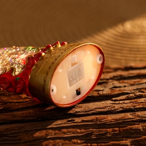 Detail view of the illuminated Christmas lantern base with power switch and battery compartment
