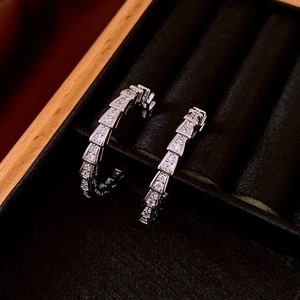 Macro shot of silver snake scale hoop earrings with sparkling cubic zirconia pavé