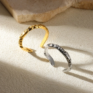 Detailed view of irregular gold and silver open rings with hammered metal texture