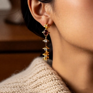 Detail view of 18k gold plated tiger eye C-shape earrings on model with retro design