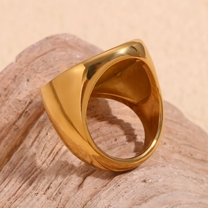 Poliertes 18K vergoldetes breites Ringband mit unregelmäßiger Oberfläche auf Naturstein