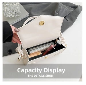 Interior view showing the capacity for phone and cosmetics in the white shoulder bag