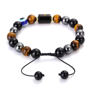 Macro shot of tiger eye beads bracelet with evil eye charm and adjustable woven cord