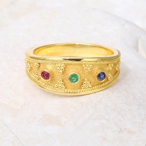 Gold textured ring with three vibrant round-cut red, green and blue gemstones