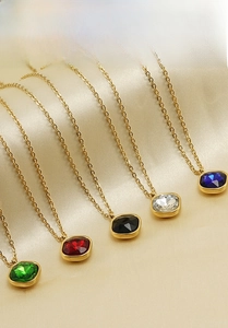 Macro detail of 18K gold plated stainless steel necklaces with colorful zircon pendants