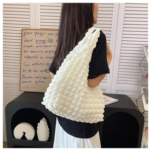Detailed view of a white ruched cloud bag featuring stylish puff textured pleated fabric