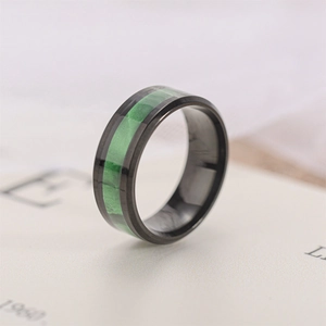 Close-up detail of a black titanium steel ring with a vibrant green center inlay