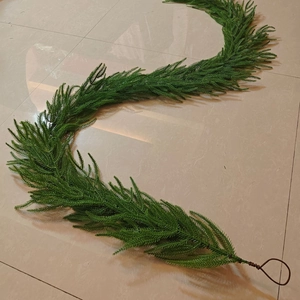 Detail of green artificial PE pine garland with flexible wire and brown hanging loop